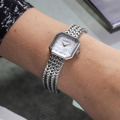 Une femme portant la montre Octogône – quartz carré – acier & nacre blanche