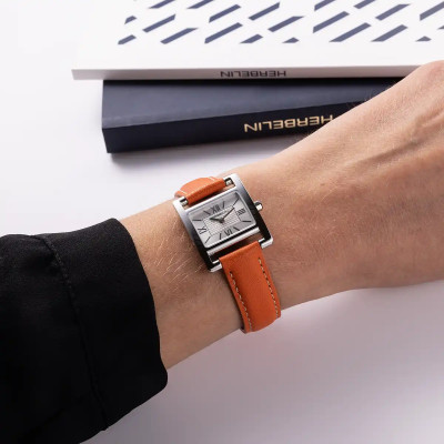 Une femme portant la montre Montre Herbelin Vème Avenue – Cuir Orange & Index