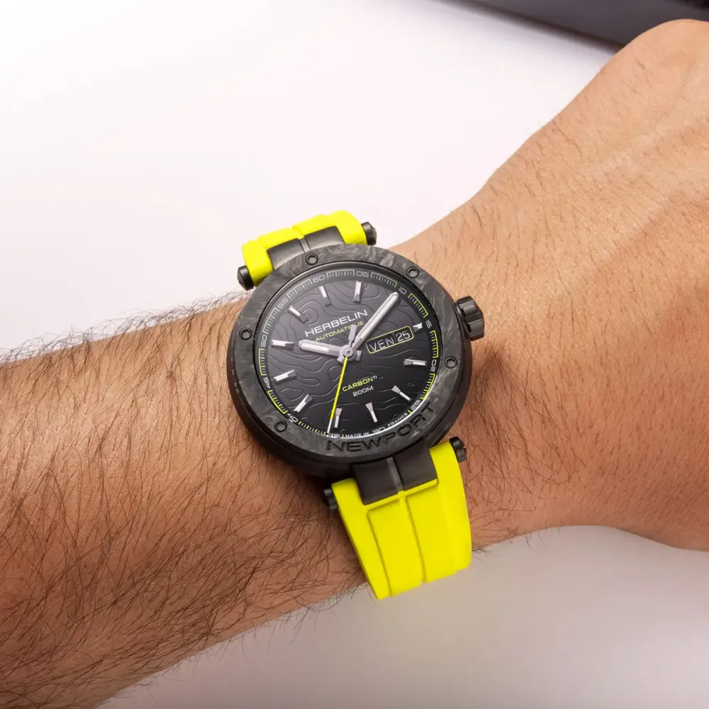 Un homme portant la montre Montre Herbelin Newport – Carbone Titane Automatique – Jaune