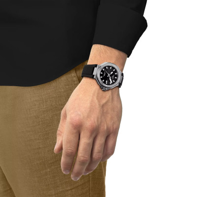 Un homme portant la montre Tissot T-Race 41mm, cadran noir, boîtier argent, bracelet synthétique.