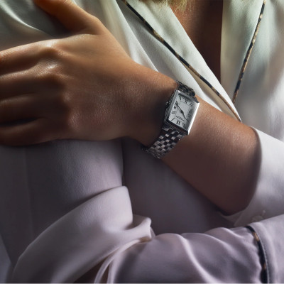 Une femme portant la montre Raymond Weil Toccata carrée, cadran blanc, bracelet argenté