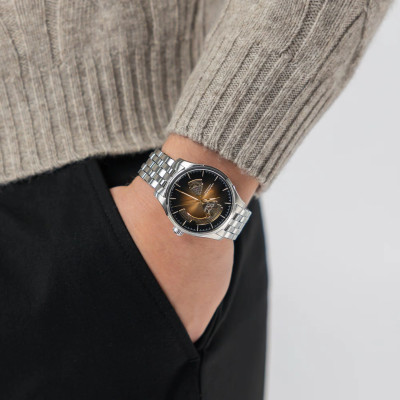 Photo avec les mains dans les poches, portant la Montre Jazzmaster Open Heart Auto 40 Mm Cadran Noir Bracelet Argenté